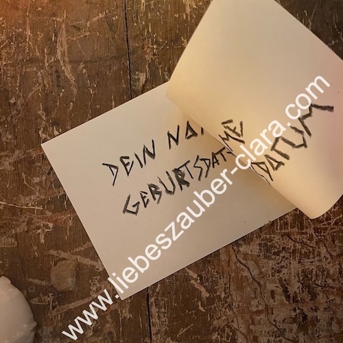 Foto das zeigt, wie die beiden Zettel so aufeinander gelegt werden, dass sich die beschriebenen Seiten berühren.