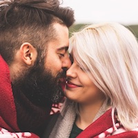 Mann und Frau wärmen draussen sich zusammen unter einer Decke